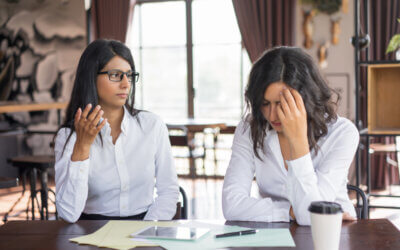 Two women in a counseling session, one gesturing while the other appears distressed